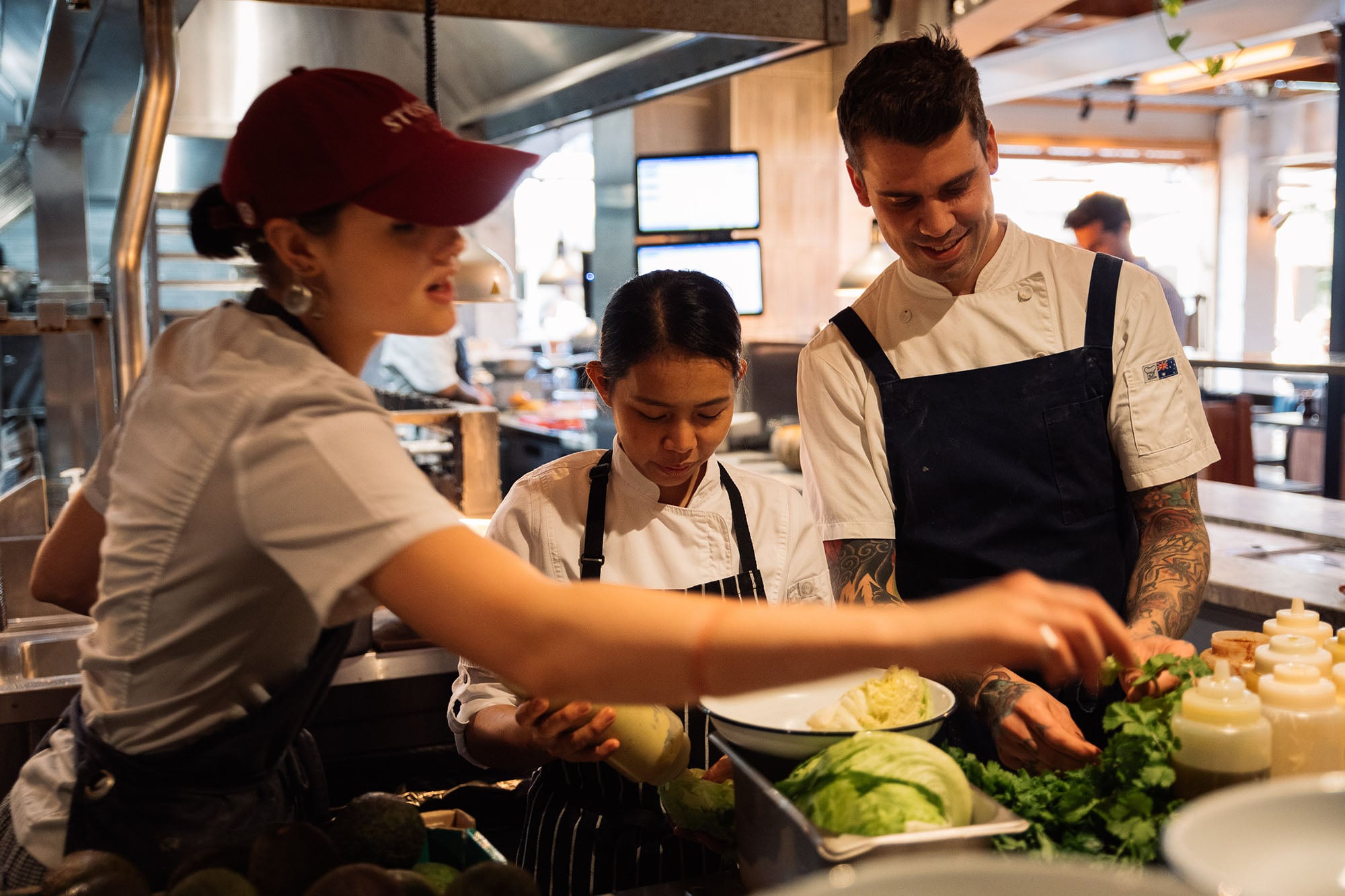 Kitchen team plating plates at a pass